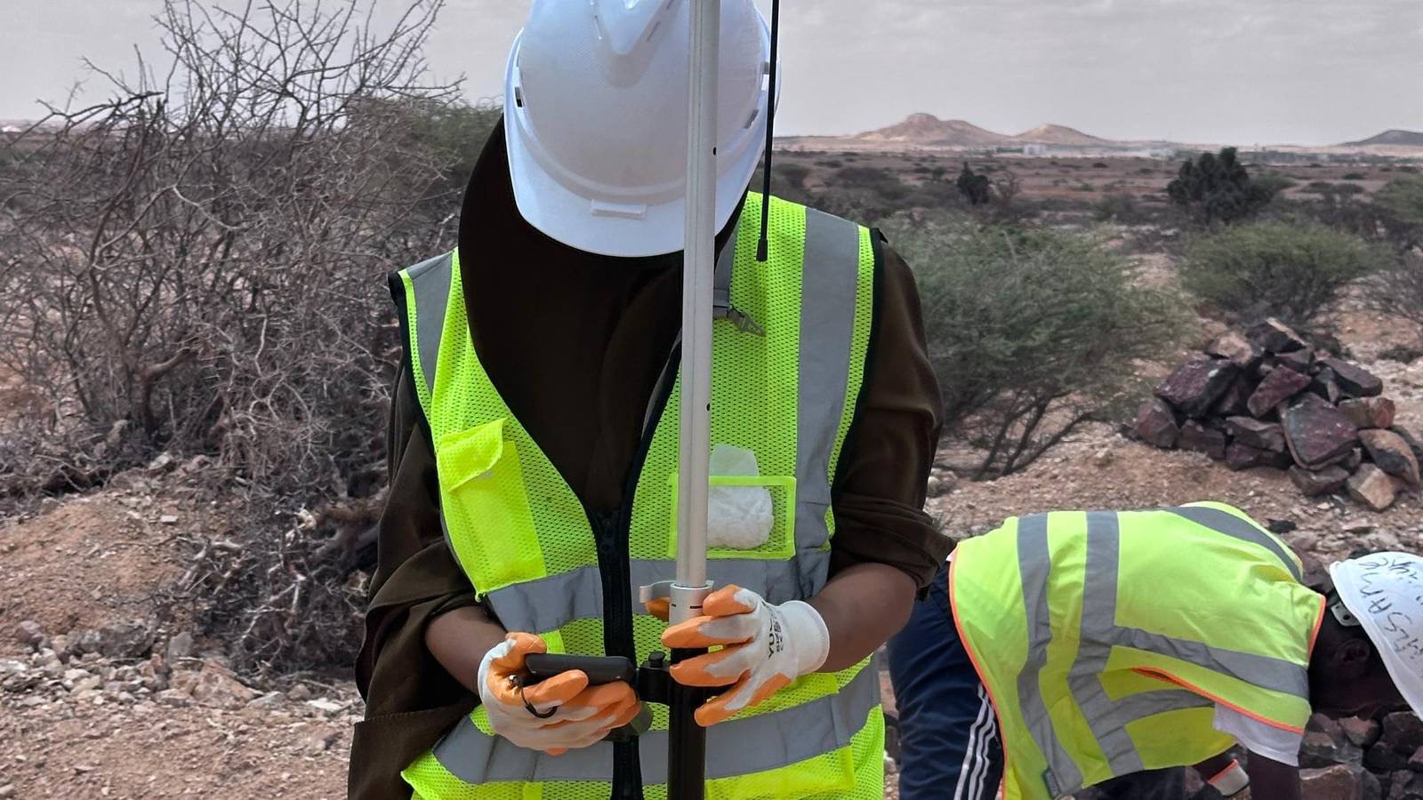 A woman engineer installing panels across a solar array in Somalia